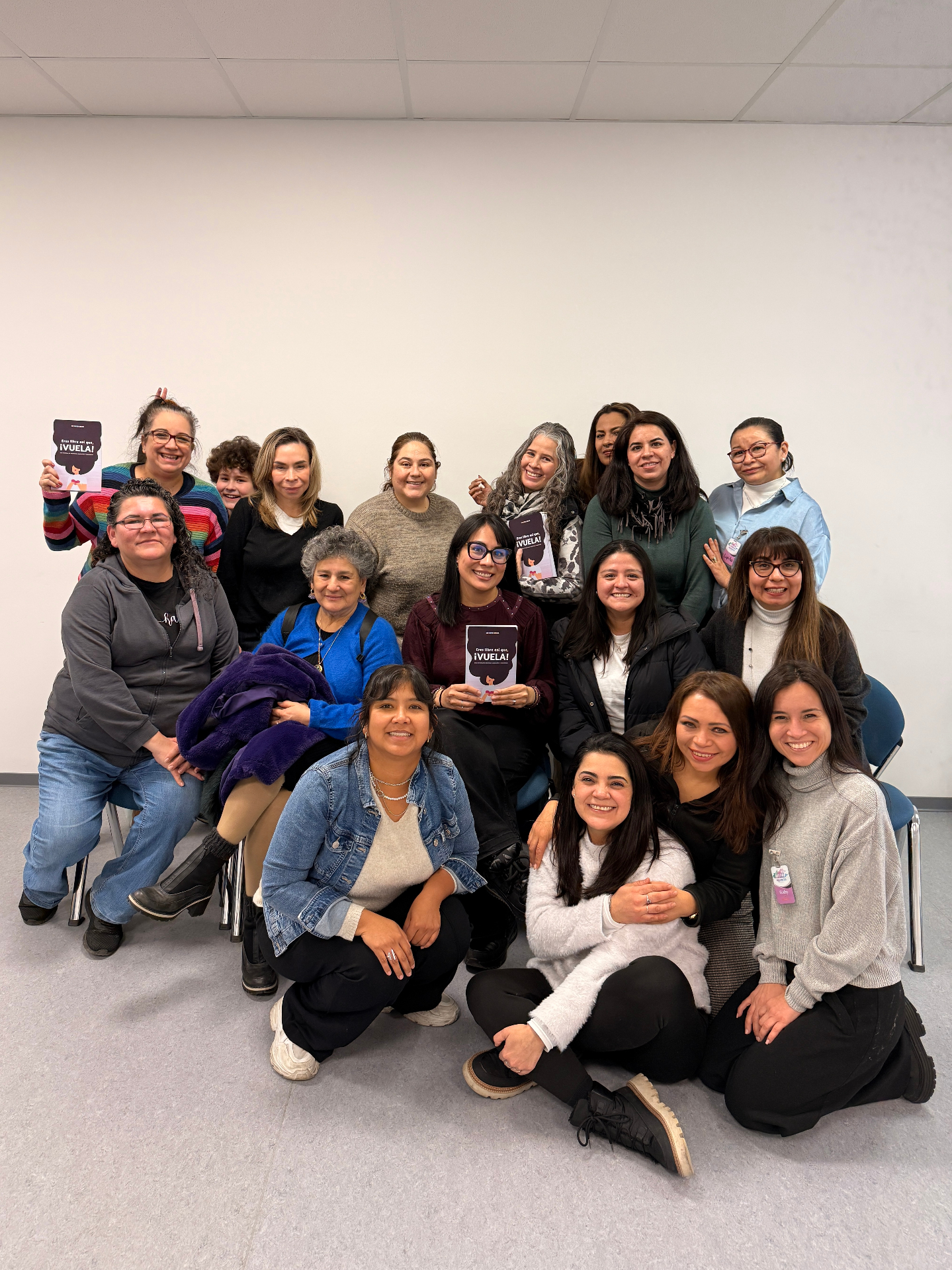 Grupo de mujeres sosteniendo el libro Eres libre, ¡así que vuela! después de un taller