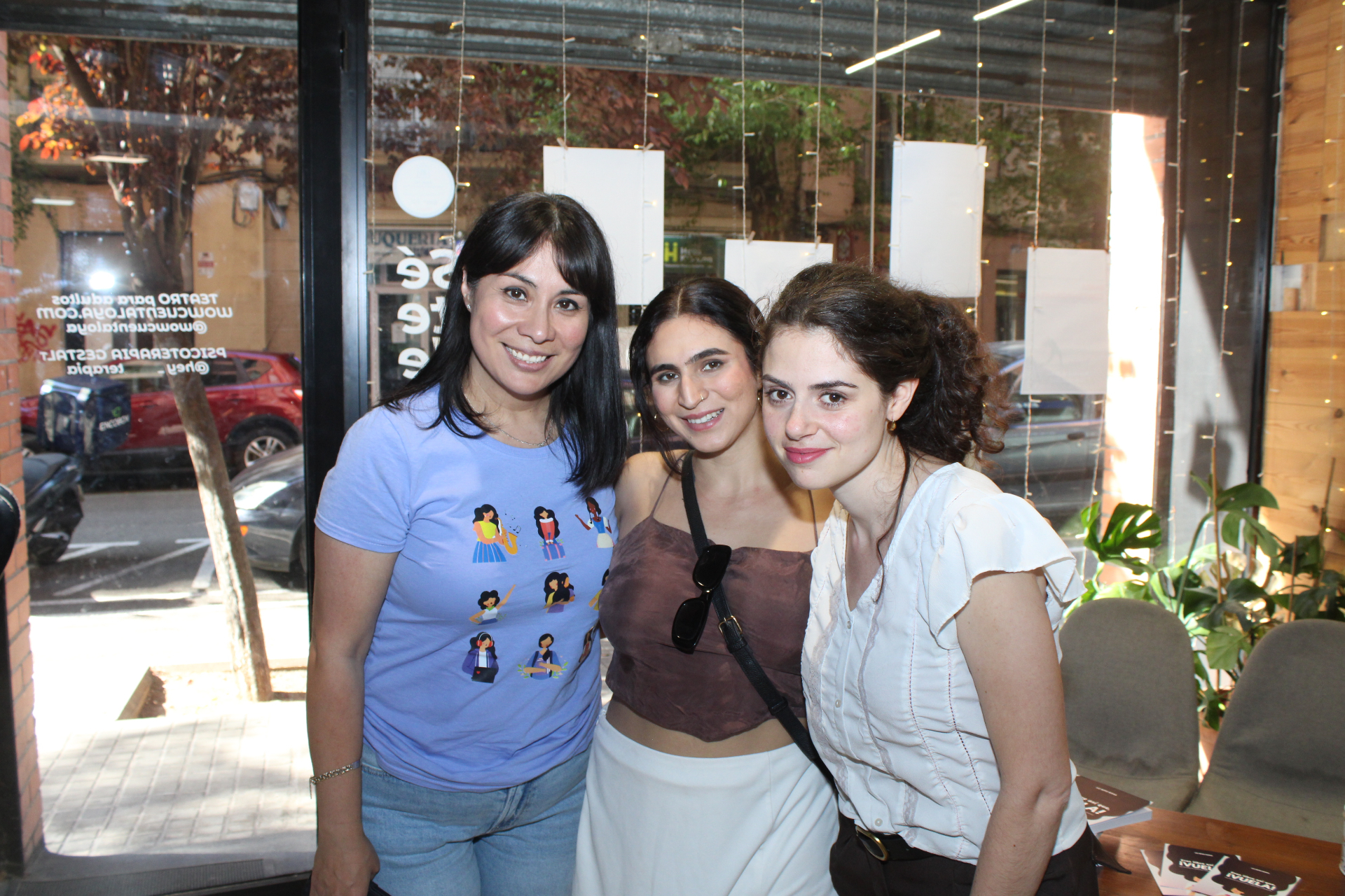 Tres mujeres sonriendo junto a ejemplares del libro durante el evento In Between en Barcelona