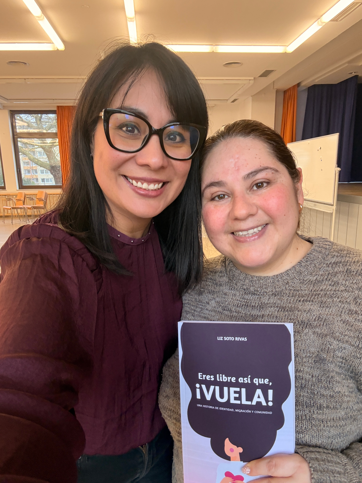 Dos mujeres sonrientes sosteniendo un ejemplar de Eres libre, ¡así que vuela!